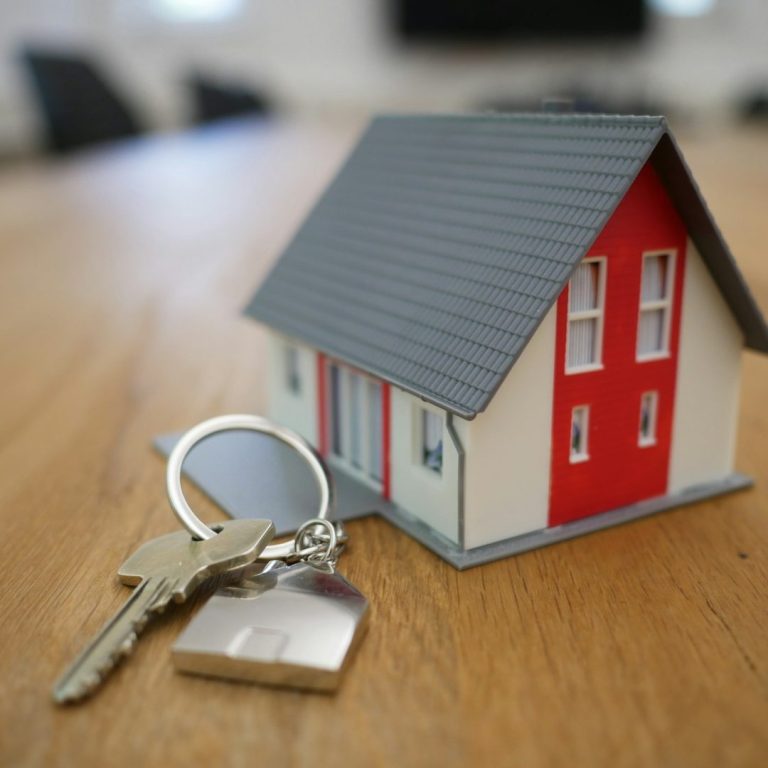 Modellhaus mit roten Akzenten und Schlüsselanhänger auf einem Tisch.