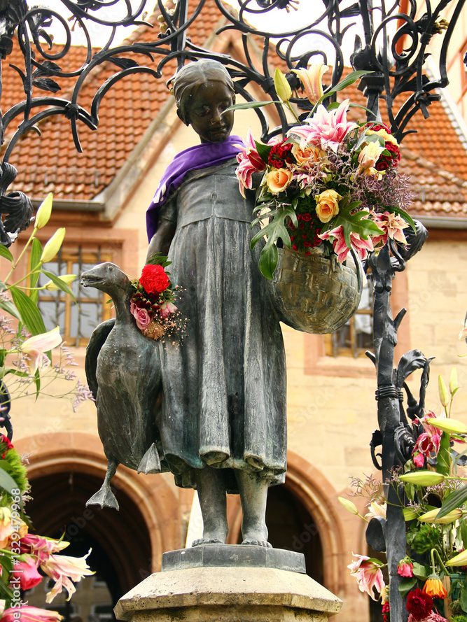 Das Gänseliesel - Wahrzeichen der Stadt Göttingen. Die Bronzestatue eines Mädchens mit einem Hund, das Blumen trägt.